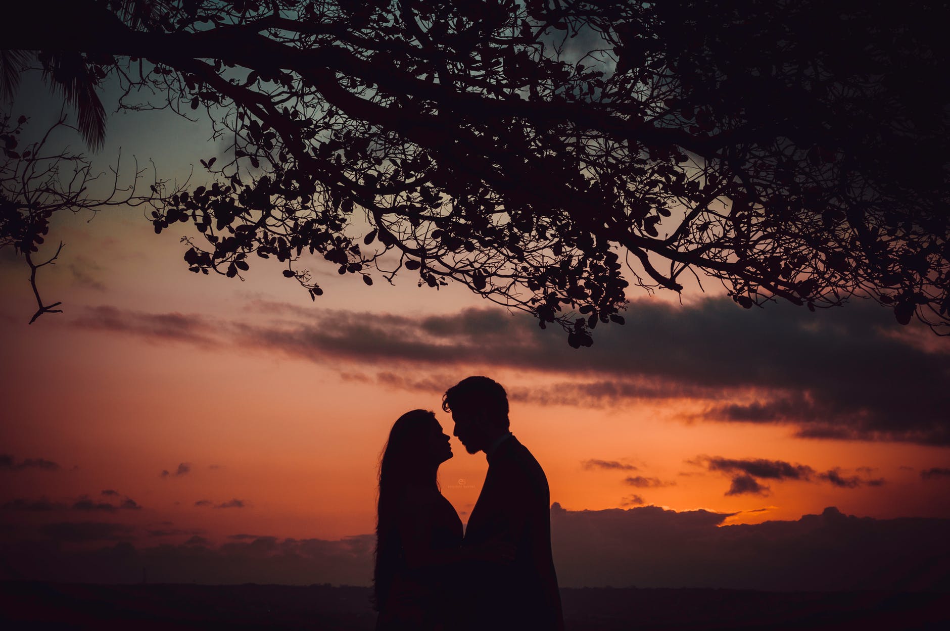 photo of couple facing each other during golden hour